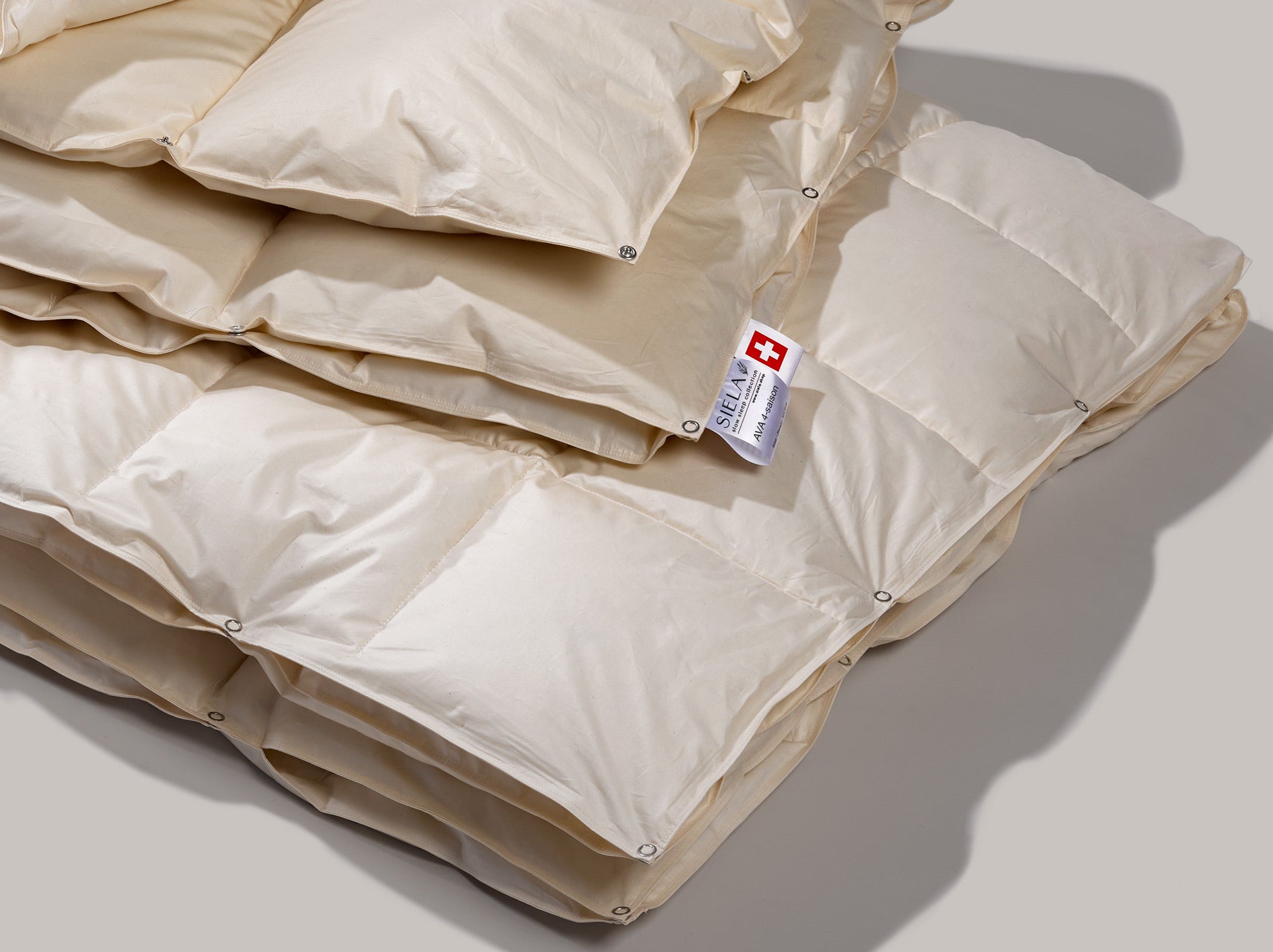 Das 4 Saisonduvet von Nahem mit der deutlichen Sicht auf die Druckknöpfe, die zeigen, dass die Duvets zusammen oder getrennt verwendet werden können.