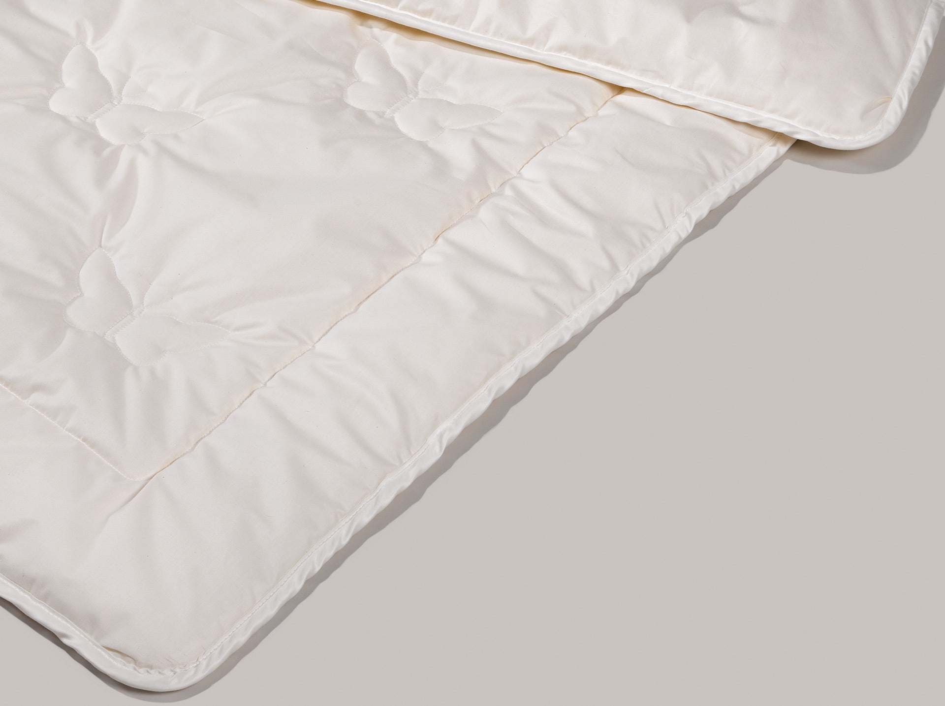 DAs Kinder Maisfaserduvet mit den Schmetterlingen als Steppmuster. 0Die Kanten des Duvets sind mit einem Band versäubert.
