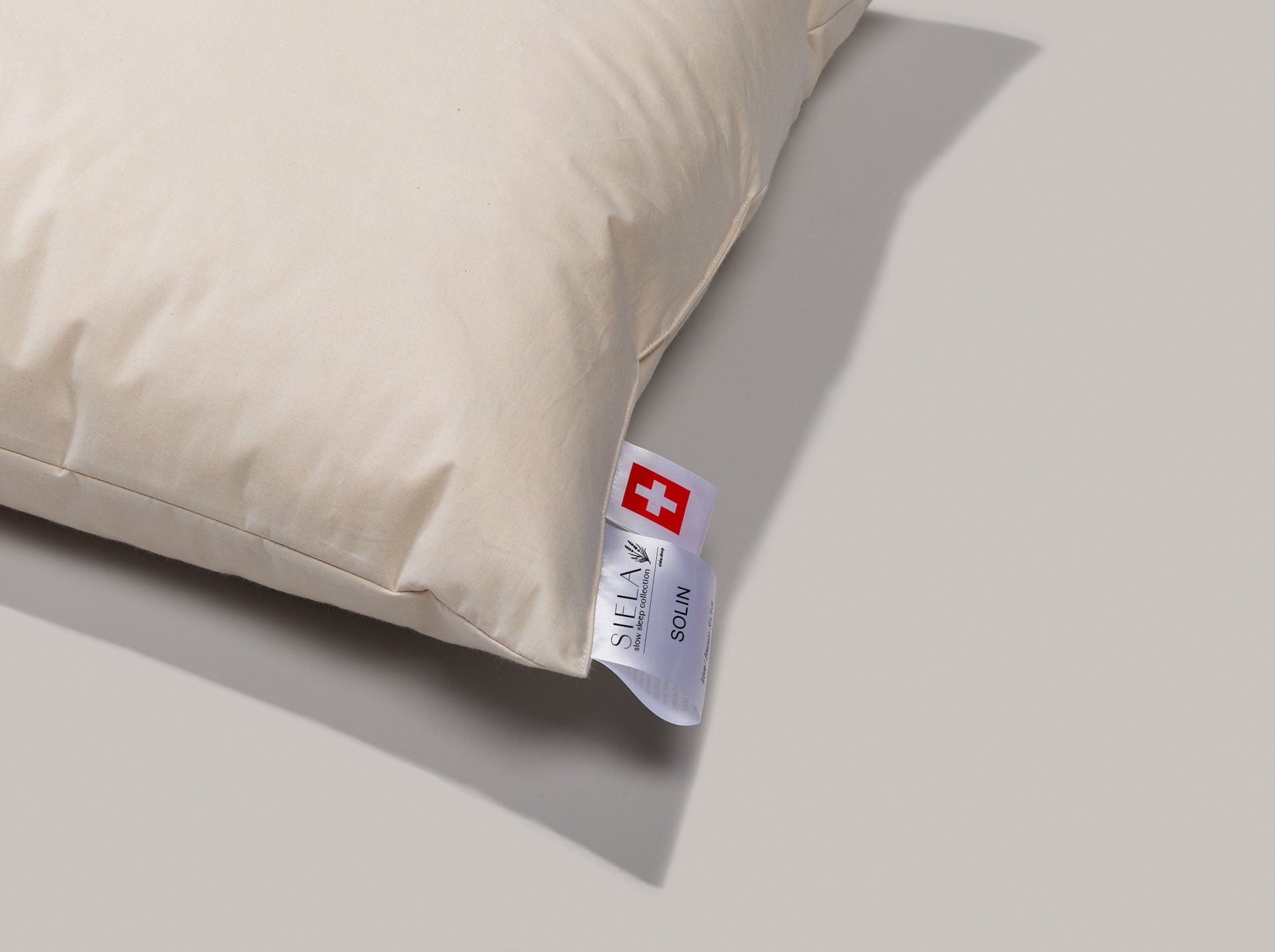 Der Stoff vom Zweikammerkissen ist deutlich erkennbar und die Etikette von Solin ist im Vordergrund gut erkennbar. Auch das Schweizer Kreuz ist sichtbar.